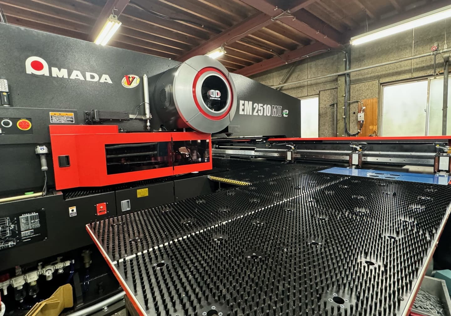 高精度な金属加工が可能なタレットパンチプレスでアルミの防衛品を加工中（深津機器製作所）